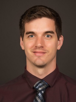a man in shirt in tie against a gray background