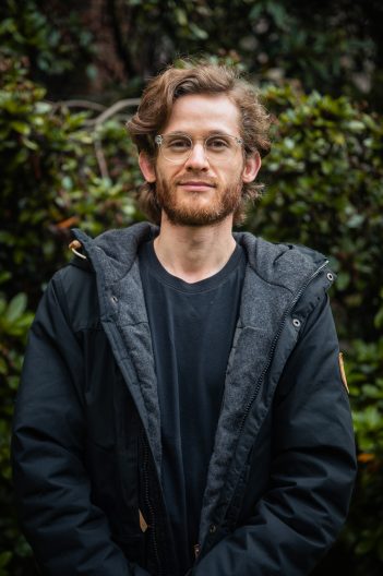 man stands near bushes