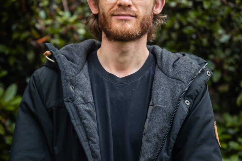 man stands near bushes
