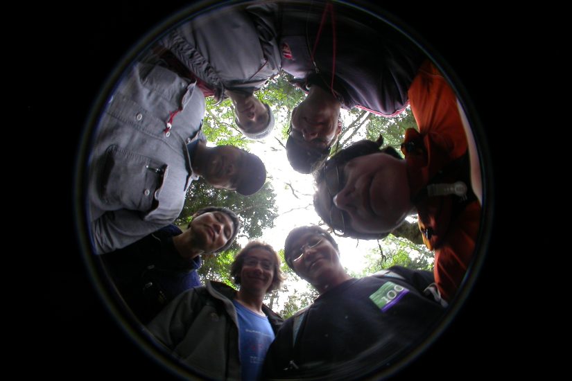 Seven people stare into a hemispherical camera.