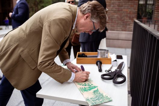 SEFS Director Dan Brown signs a section of the ribbon from the Anderson Hall Ribbon Cutting Ceremony. The ribbon was produced in the Wollenberg Bioresource Paper Lab and imprinted with native plants from the SEFS courtyard.